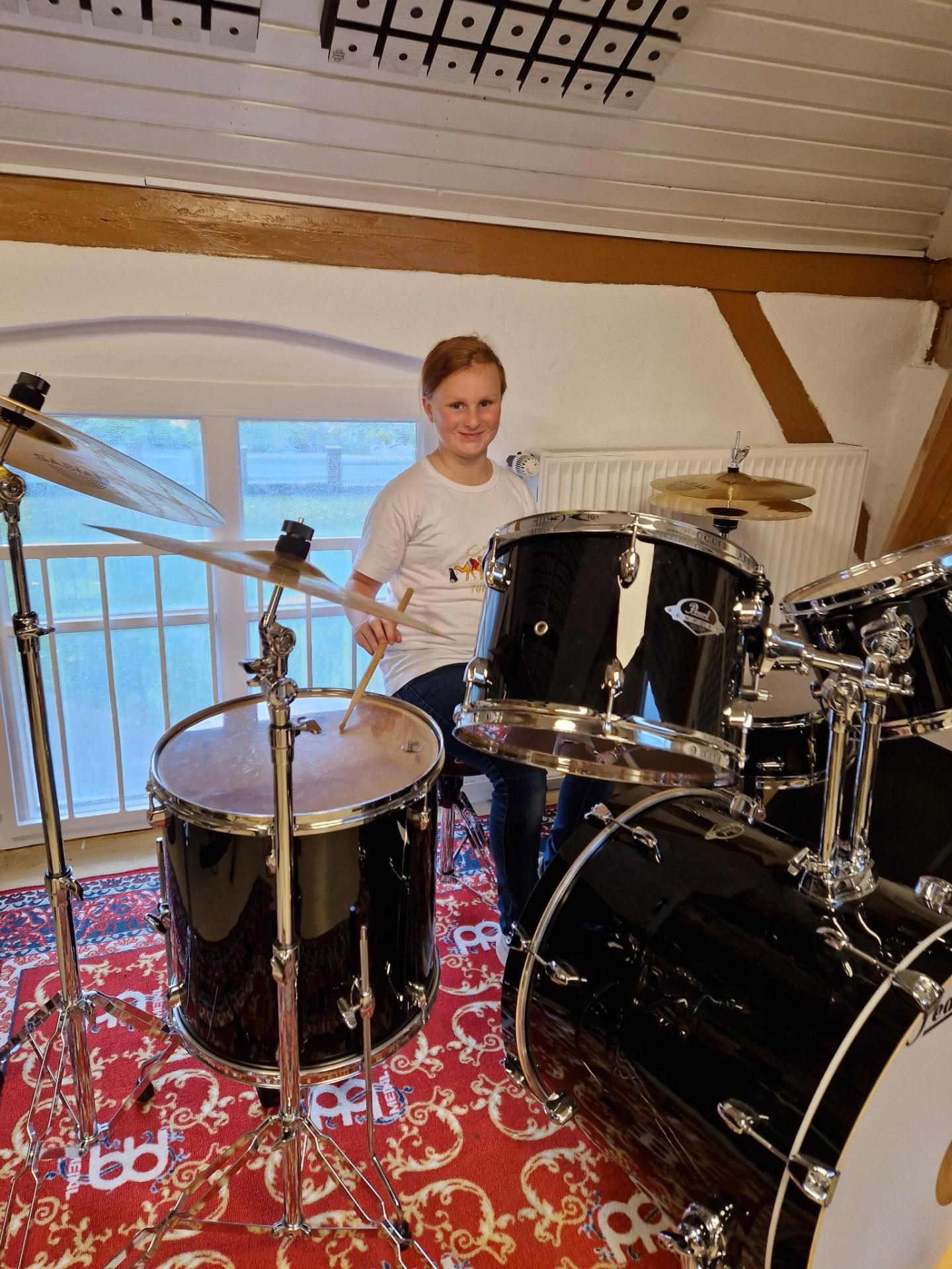 Finja probiert das Schlagzeug in der Musikwerkstatt aus (©Gemeinde Stockelsdorf)